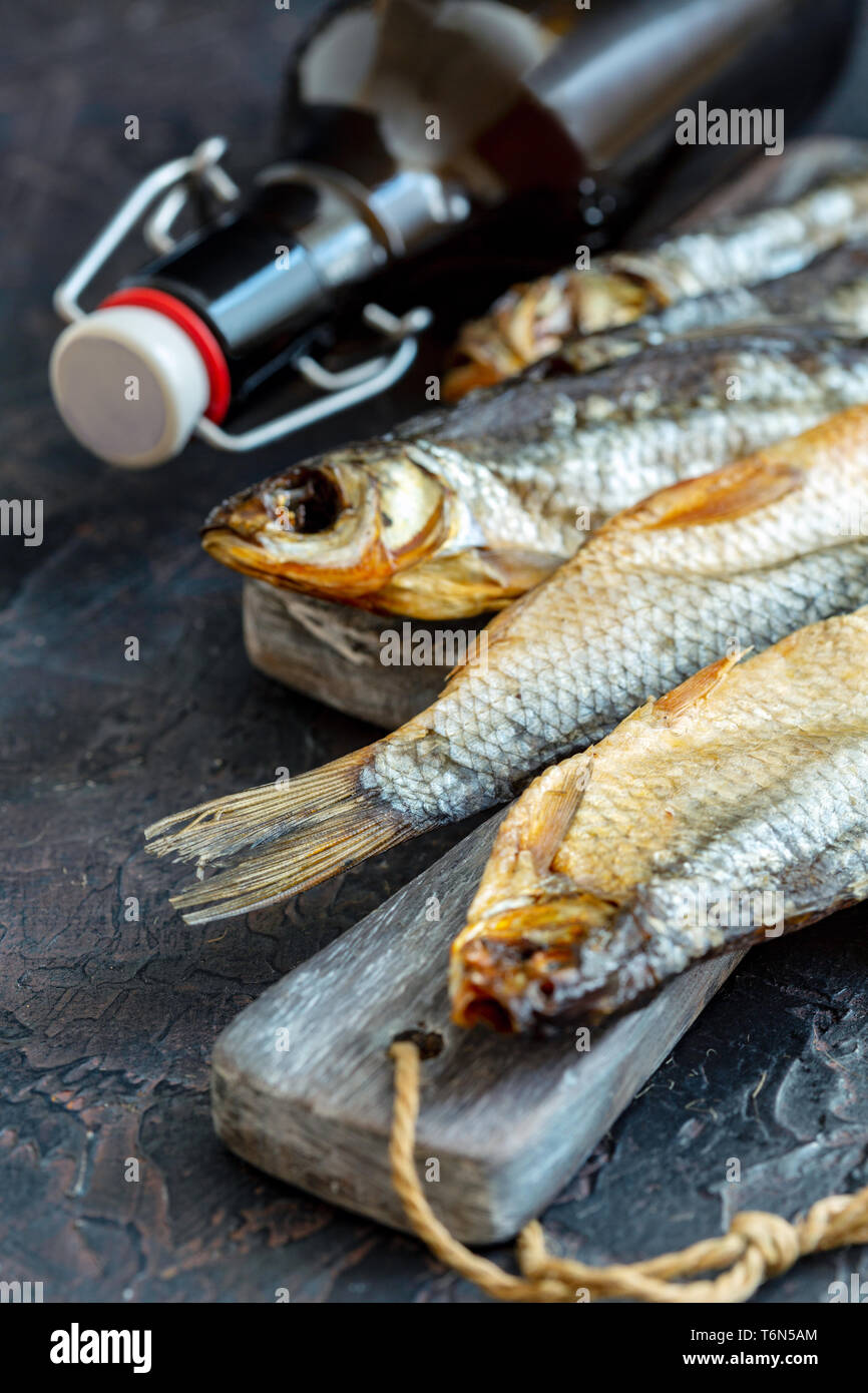 Séchage du poisson salé et une bouteille de bière. Banque D'Images