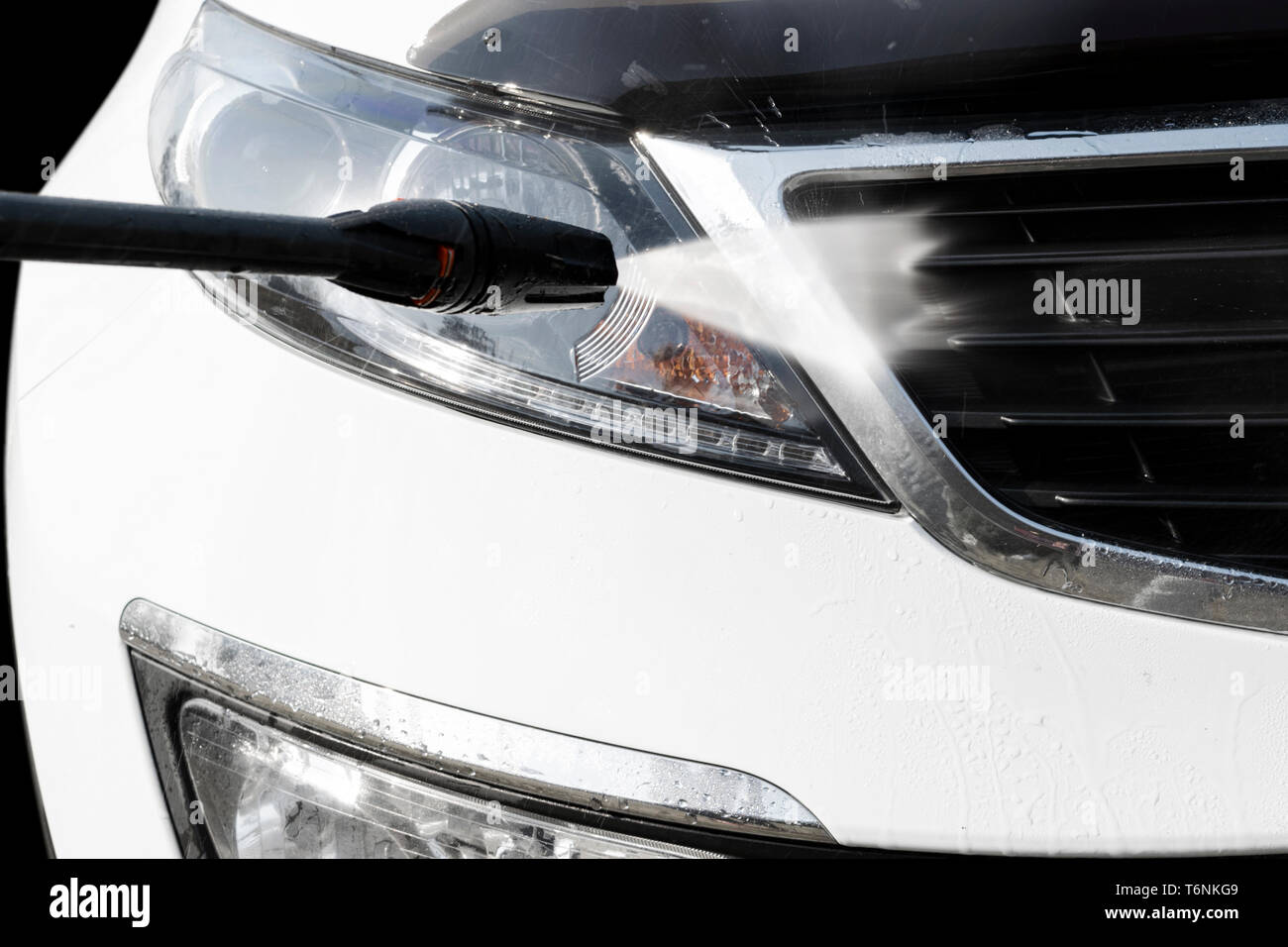 Lave-auto manuel avec de l'eau sous pression à l'extérieur. Lavage de voiture en été. Voiture à l'aide de nettoyage de l'eau sous pression. Esthétique auto. Lave main. Un éclairage doux Banque D'Images