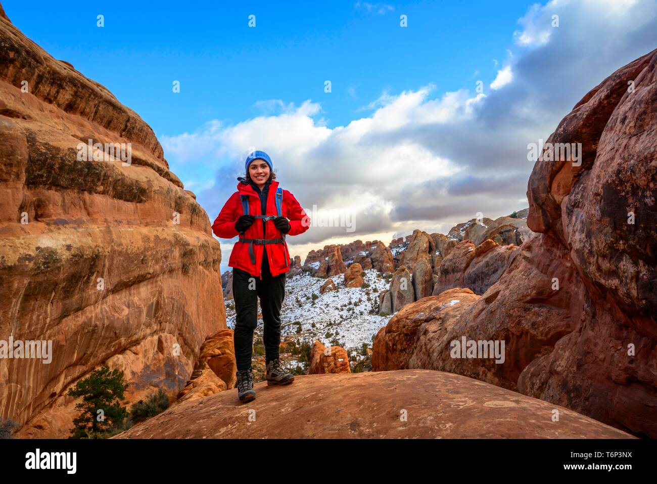 Jeune femme, tourisme randonnée sur les falaises de grès en hiver, Devil's Garden Trail, Arches National Park, Utah, USA Banque D'Images