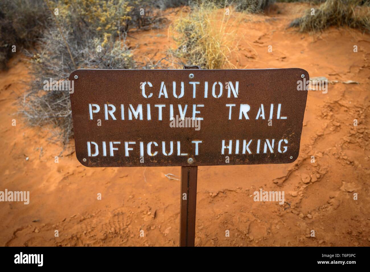 Attention, la primitive difficile randonnée, signer avec avertissement de sentier non garantis, Devil's Garden Trail, Arches National Park, Utah, USA Banque D'Images