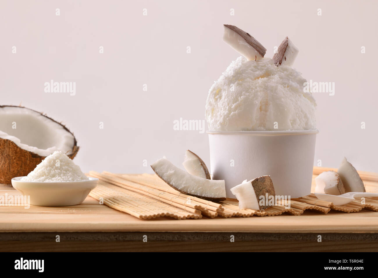 Glace coco tasse décorée avec des cocotiers bordée sur une table en bois. Composition horizontale. Vue de face. Banque D'Images