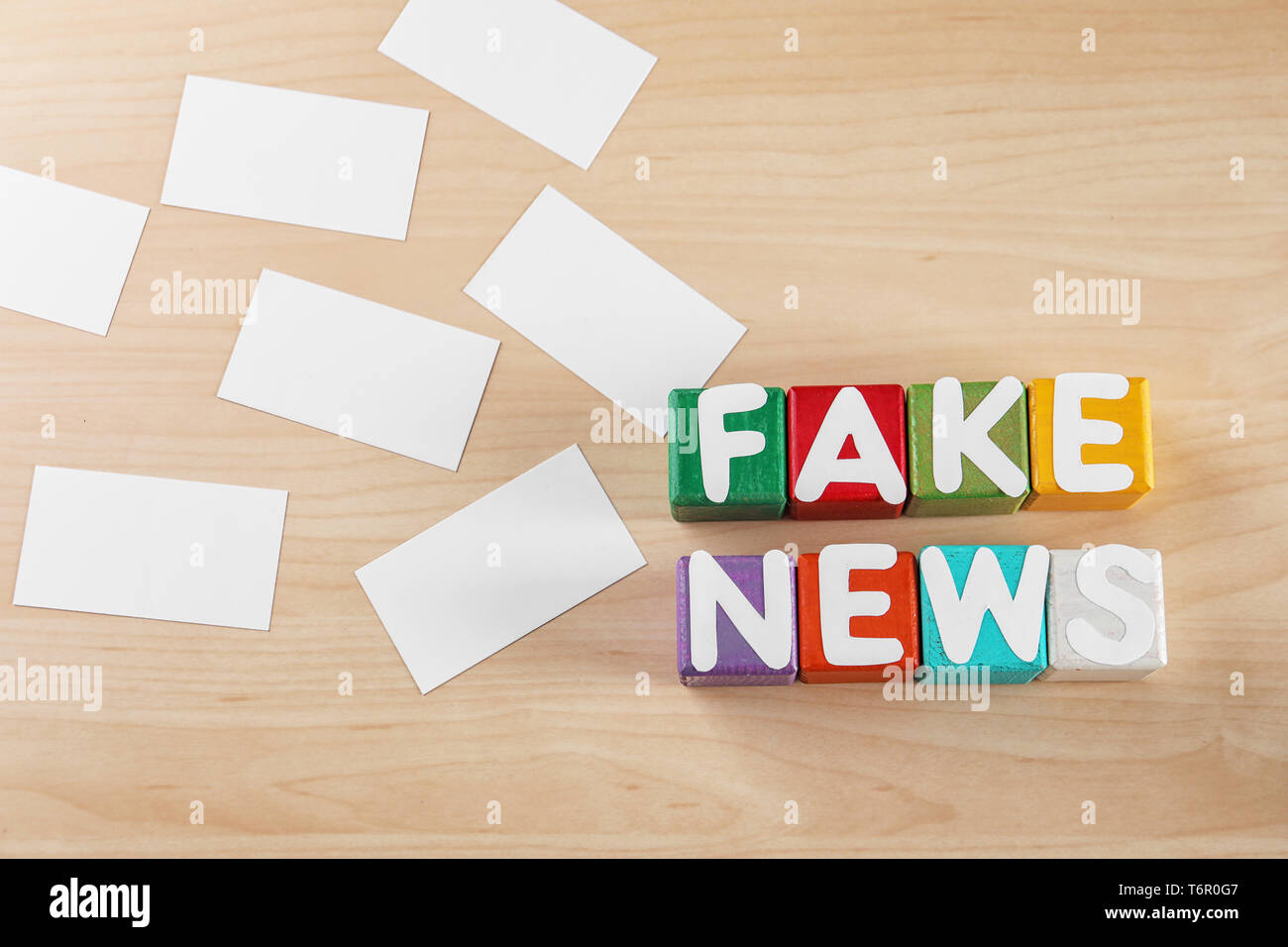 Mots FAKE NEWS faits de cubes avec des lettres sur fond de bois Banque D'Images