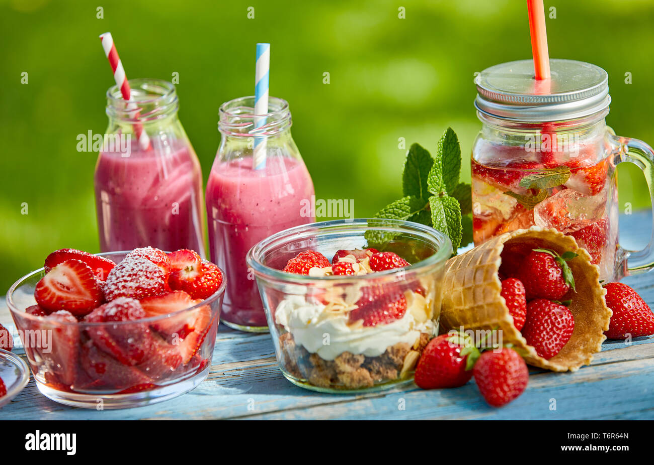 Frais, doux, l'été en bonne santé boisson fouettée aux petits bols et jus  de fruits sur une table d'extérieur lumineux Photo Stock - Alamy