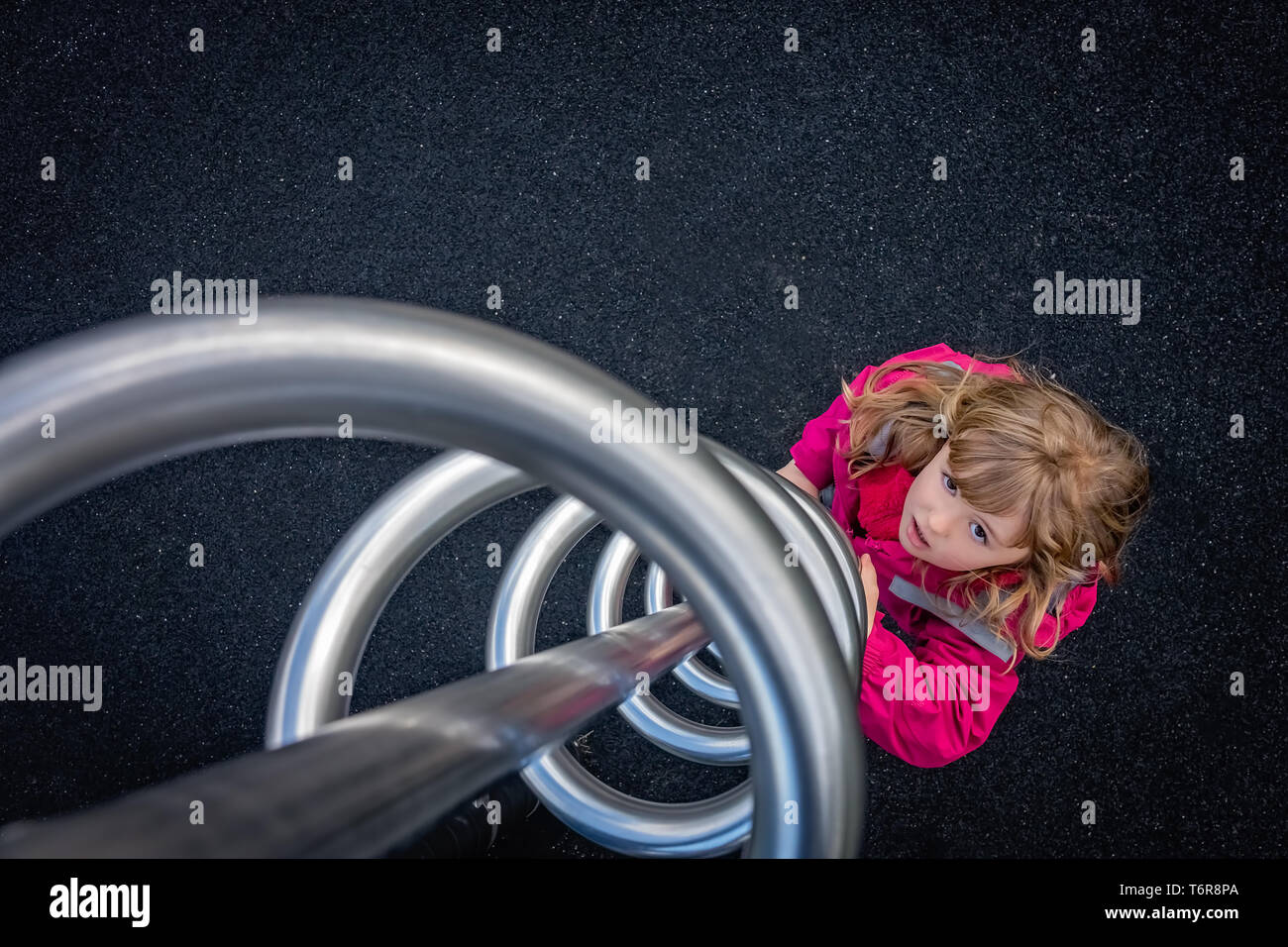 Girl prépare à grimper twisted metal tourbillonner sur une aire de jeux Banque D'Images