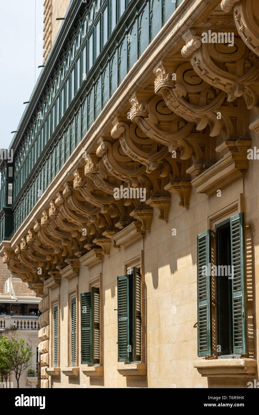 Une ligne de corbels en calcaire décorés soutient le balcon de la galerie du grand maître, situé à l'angle de la rue du vieux théâtre du palais du grand maître à la Valette Banque D'Images