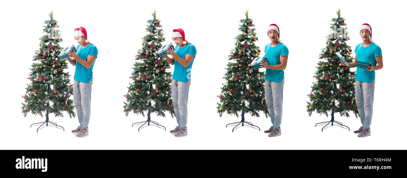 Jeune homme decorating Christmas Tree isolated on white Banque D'Images