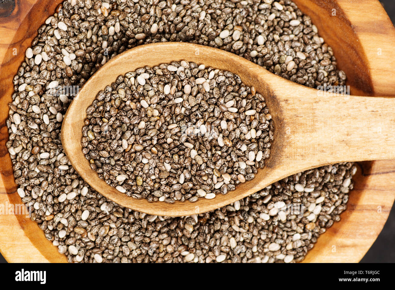 Les graines de Chia bio à plat sur fond de béton foncé. Vue d'en haut. Concept d'aliments sains. Banque D'Images