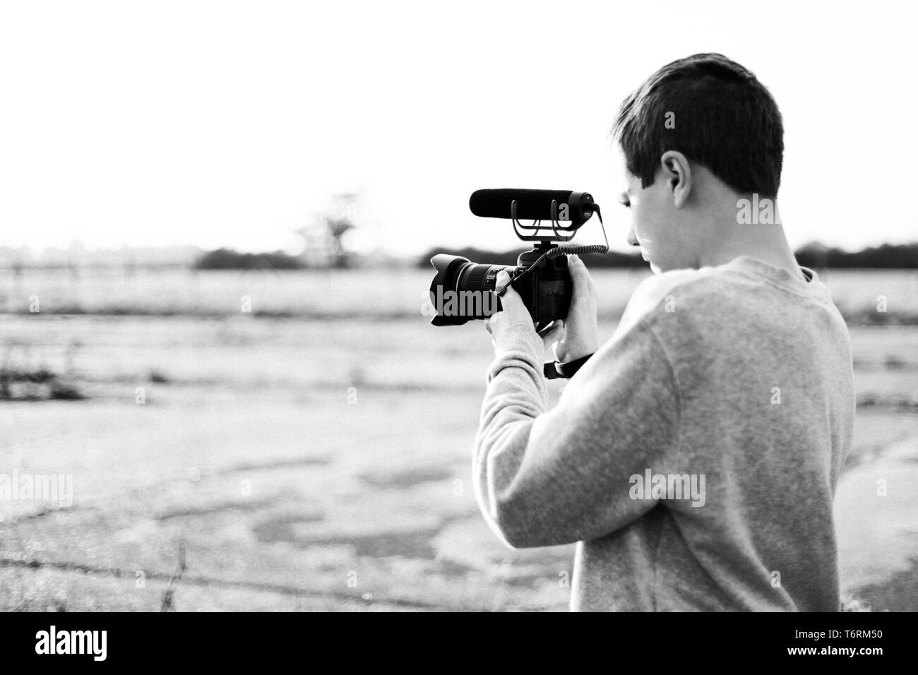 Les jeunes vidéastes l'étude et l'utilisation de caméra avec microphone mirrorless joint pour créer une vidéo. Coucher du soleil de bougies met en évidence le contraste. Banque D'Images