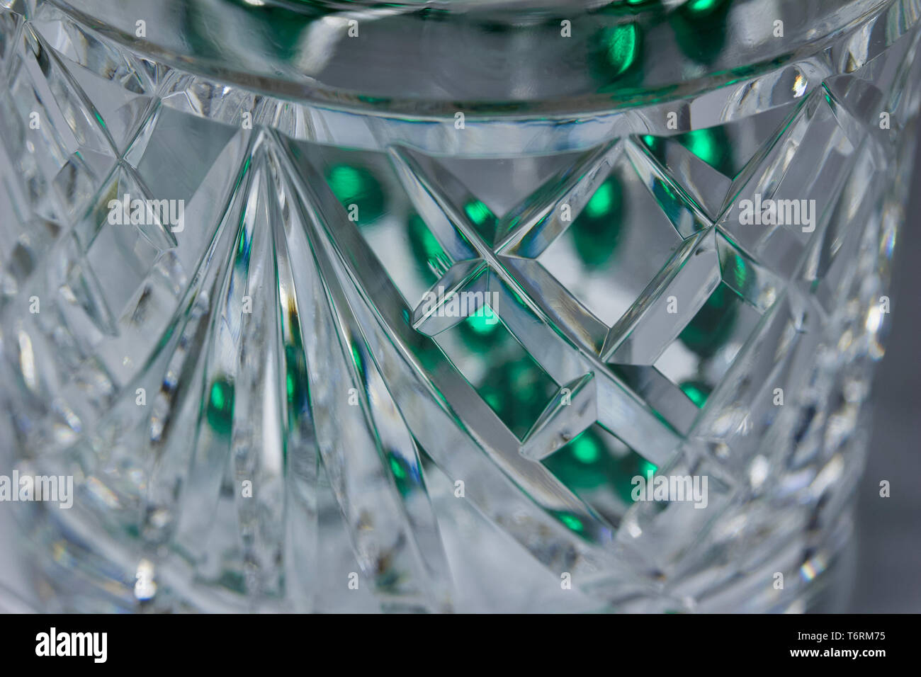 L'art abstrait macro fond de belle main du cristal au plomb avec tasse conçoit et facettes, sous l'effet bokeh vert Banque D'Images