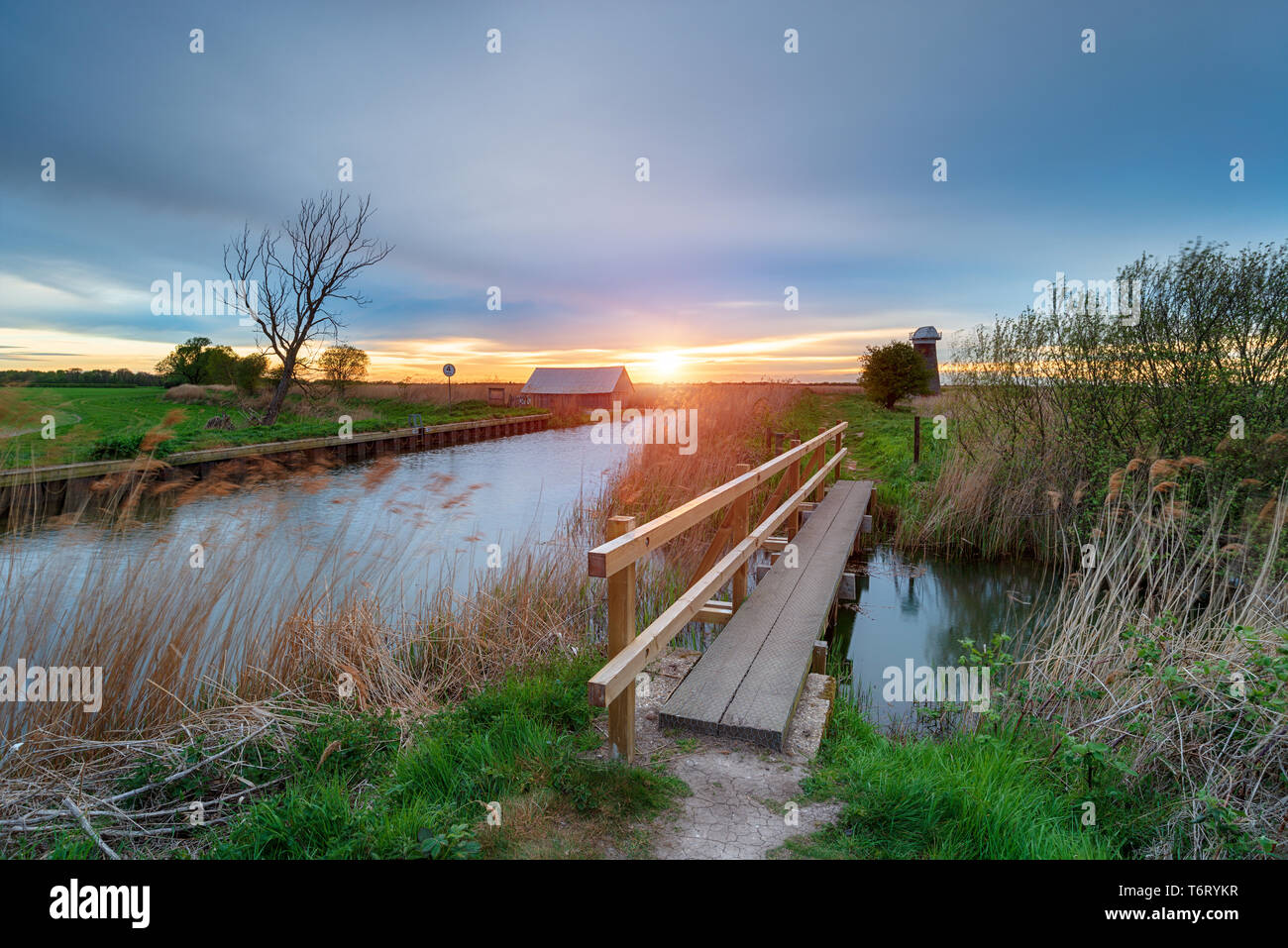 Coucher de soleil sur une passerelle menant à Martham large sur la rivière Thurne dans les Norfolk Broads Banque D'Images