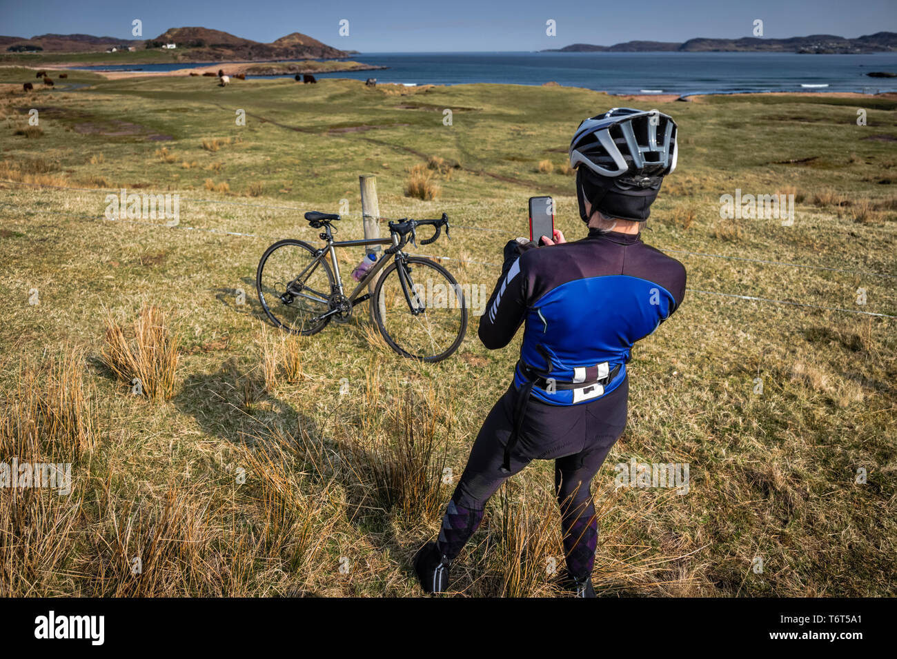 Cycliste féminine capture la beauté du paysage le long de Loch Ewe, Poolewe, côte ouest de l'Écosse, au Royaume-Uni. Banque D'Images