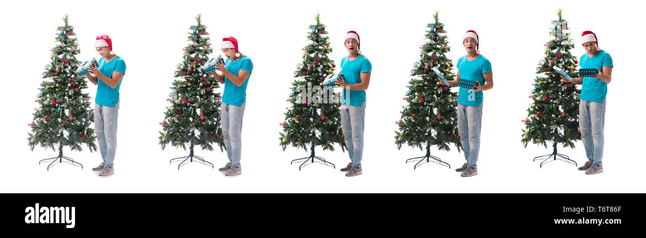 Jeune homme decorating Christmas Tree isolated on white Banque D'Images