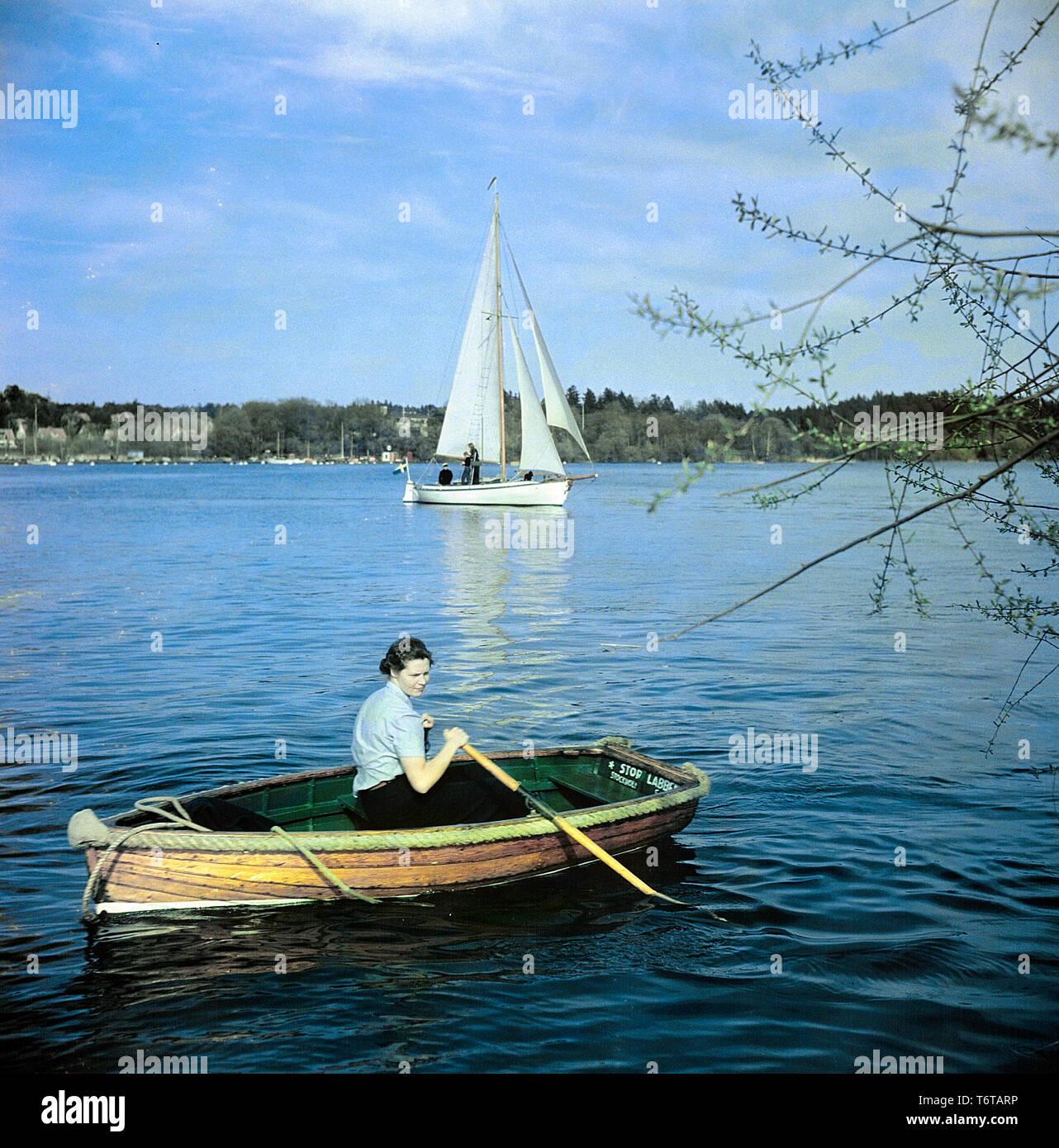 1950 Style de vie. Les lignes d'une femme d'un petit bateau en bois. Dans  l'arrière-plan d'un bateau à voile avec ses voiles. La Suède 1950 ref  BV88-4 Photo Stock - Alamy