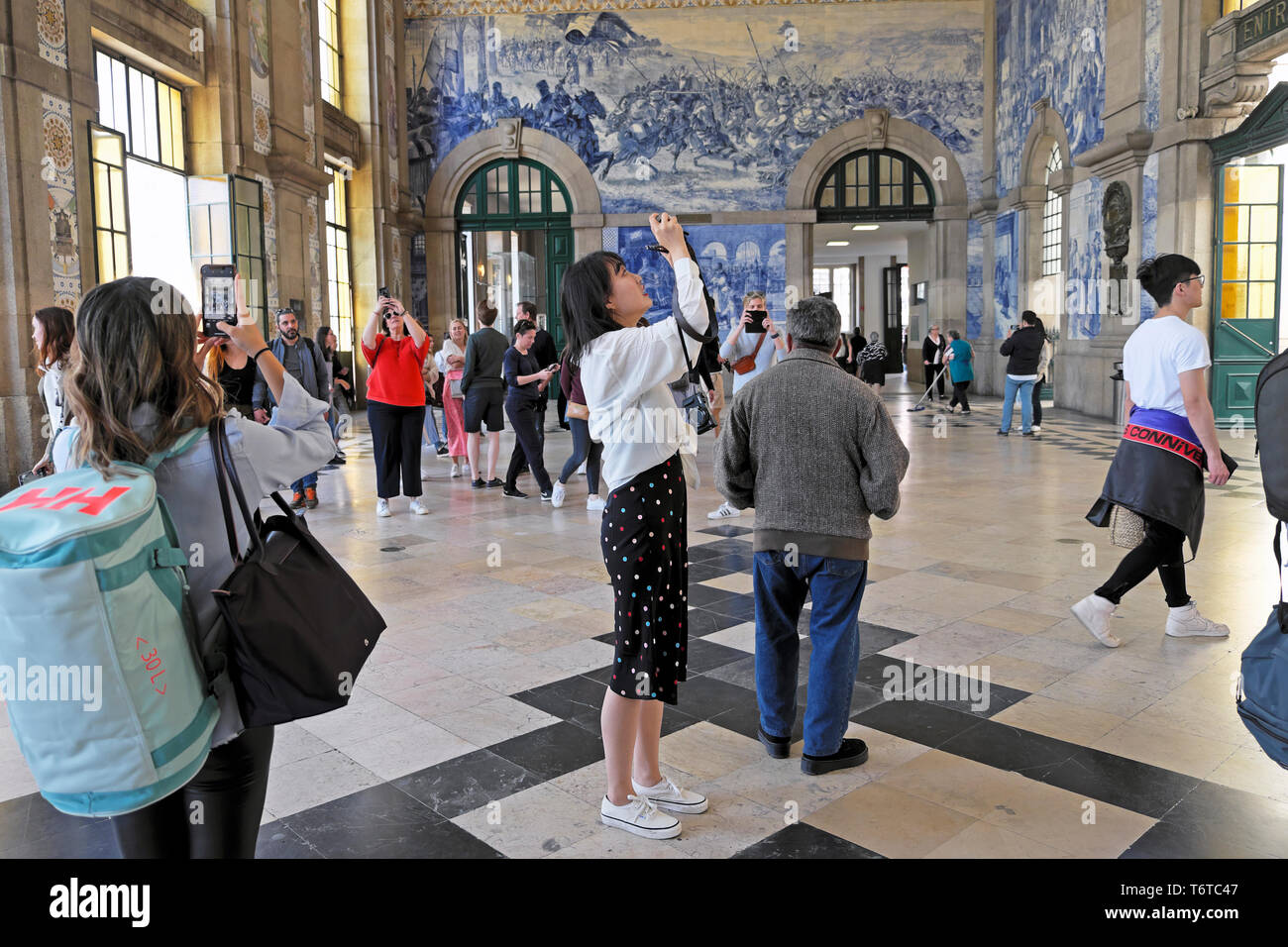Tourisme photographiant des tuiles azulejo dans la salle centrale de la gare de Sao Bento gares ferroviaires dans la ville de Porto Portugal Europe KATHY DEWITT Banque D'Images