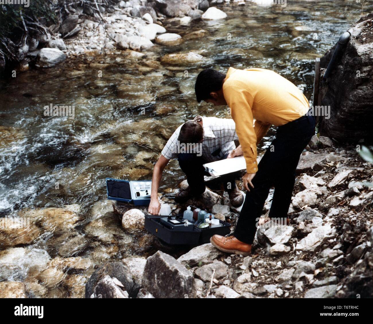 Deux chercheurs de prélever des échantillons d'eau d'un ruisseau dans le Ruby Mountains, Elko Comté (Nevada), 1975. Image courtoisie du département américain de l'énergie. () Banque D'Images