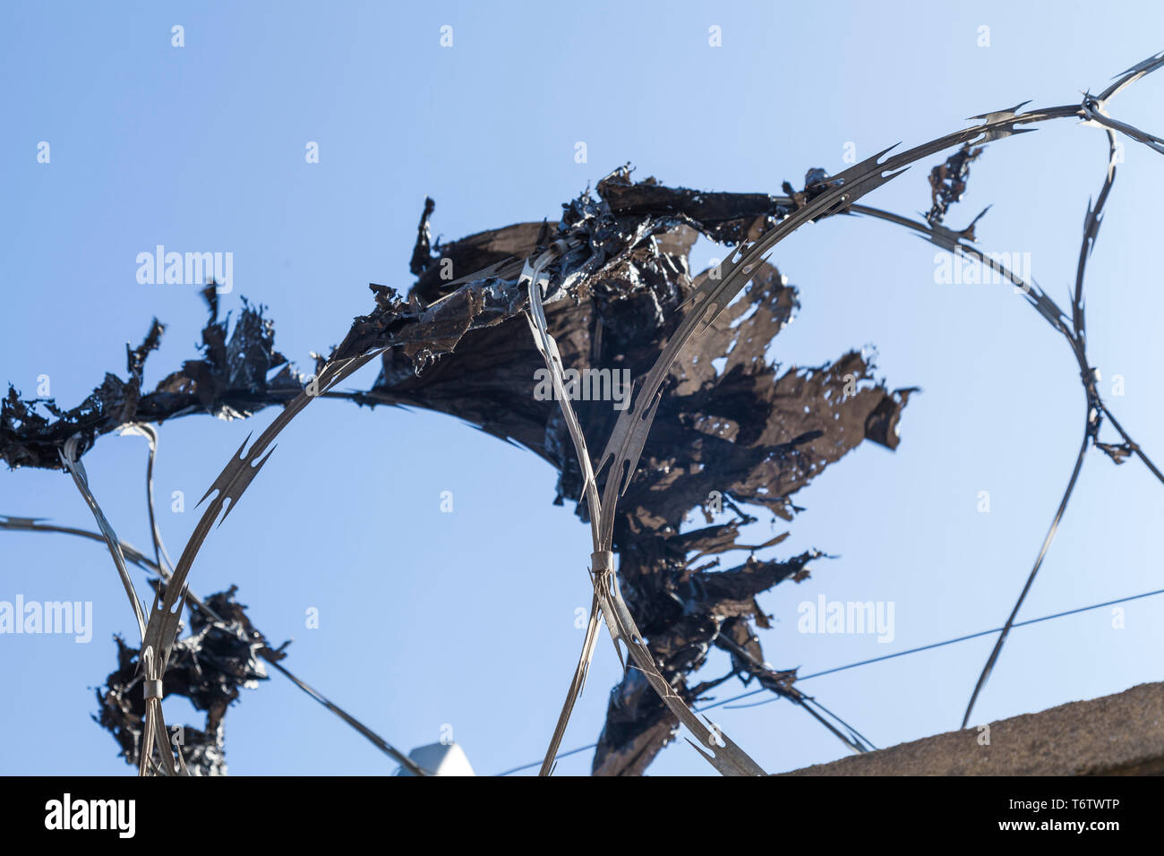 Close up de barbelés sur le dessus d'une clôture à Hartlepool,Angleterre,UK avec du plastique pris dans le fil Banque D'Images