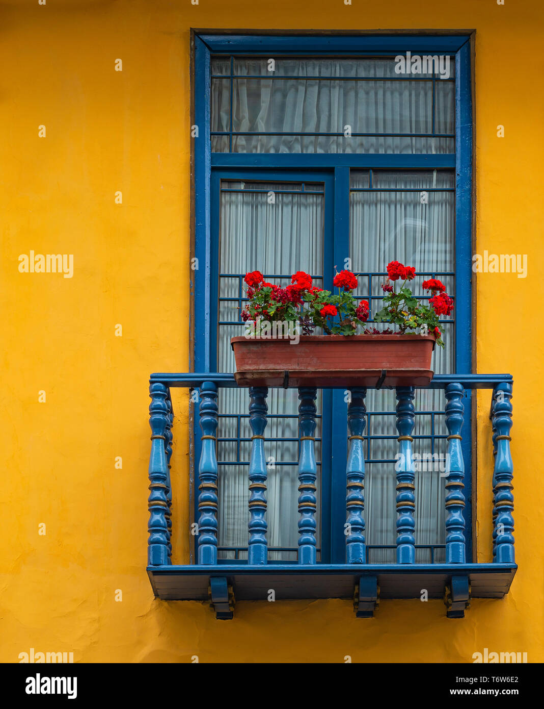 Balcon avec châssis de fenêtre bleu et jaune mur dans le centre-ville historique de Cuenca, Équateur. Banque D'Images