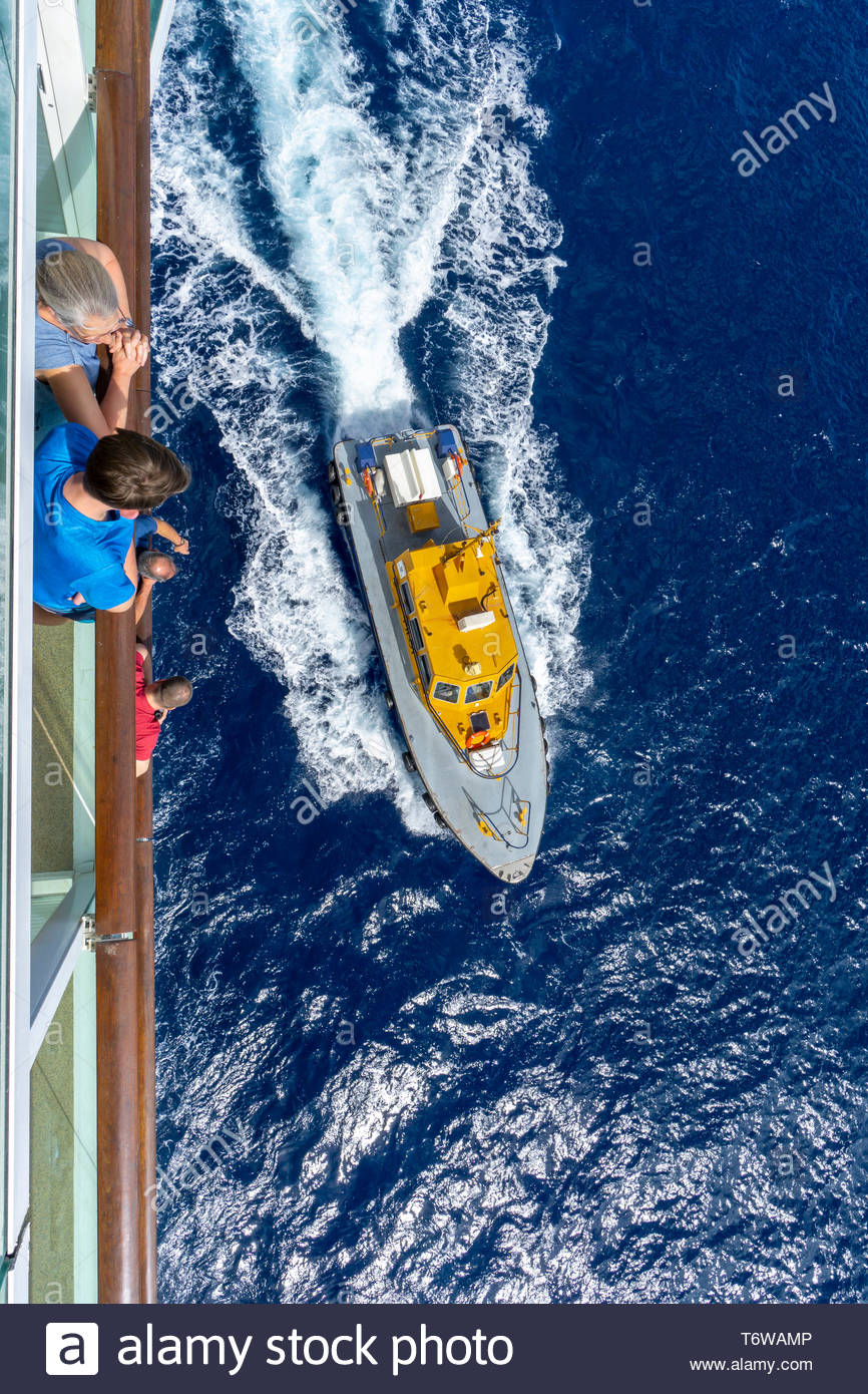Les passagers des navires de croisière regarder un bateau pilote d'un projet pilote de retour à la Barbade, une île royaume de Commonwealth dans l'Atlantique Nord dans la région des Caraïbes. Banque D'Images