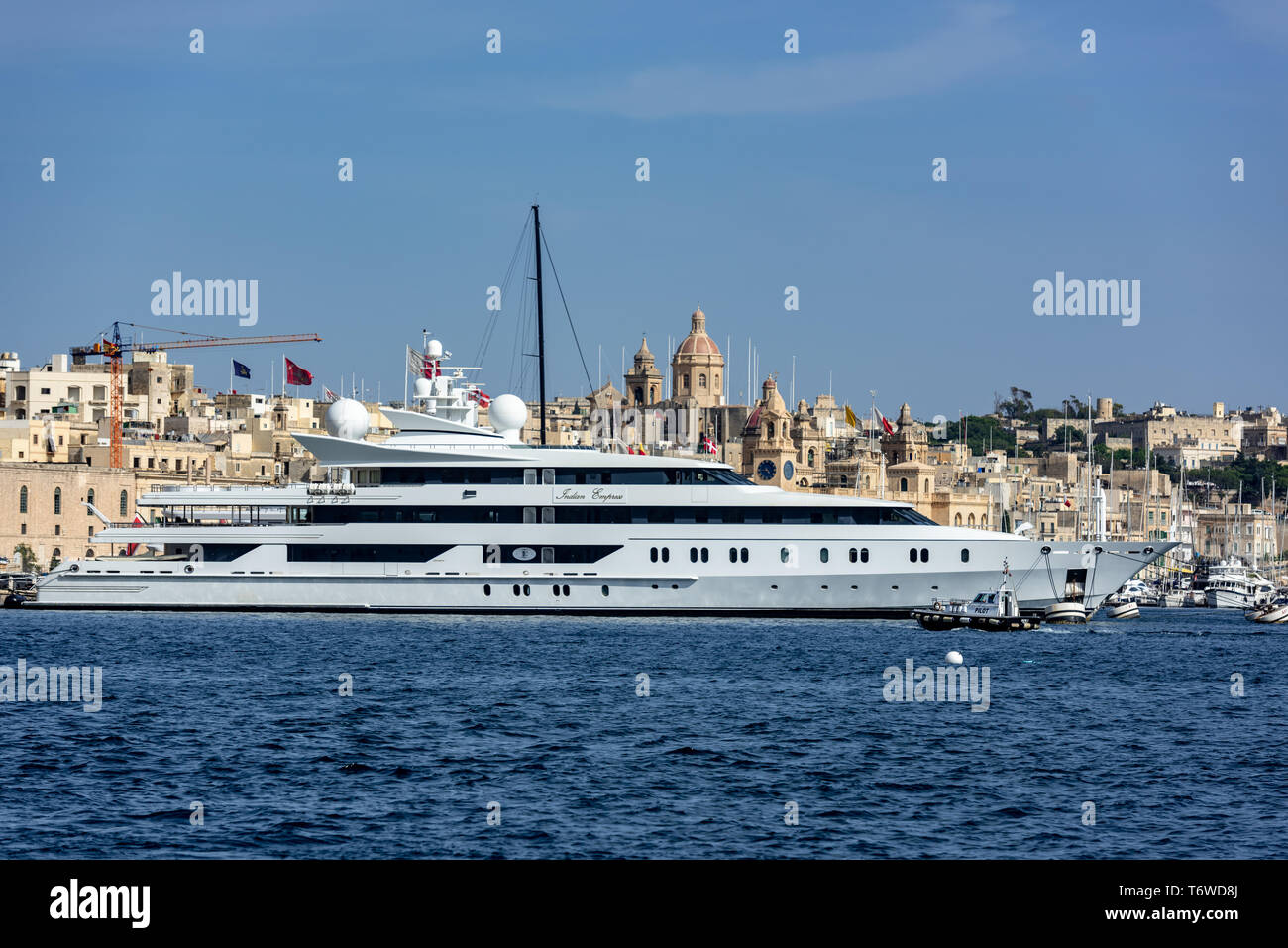 Le yacht de luxe Indian Empress de 95 mètres dans le Grand Port de Birgu, Malte avec les dômes des églises de St Anne et de St Philip en arrière-plan Banque D'Images