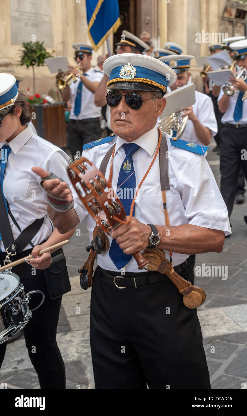 Un bandsman marchant dans le propre groupe du roi jouant le tambourin lors d'une procession de Sette Giugno dans la rue Republic à la Valette Banque D'Images