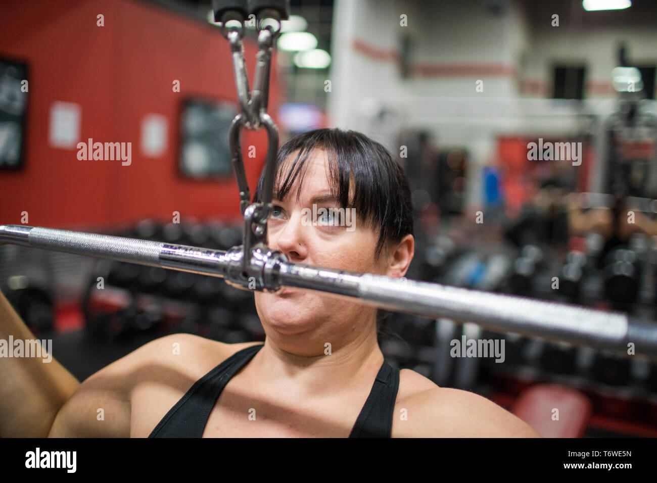 Forte femme exerçant sur la machine in gym Banque D'Images