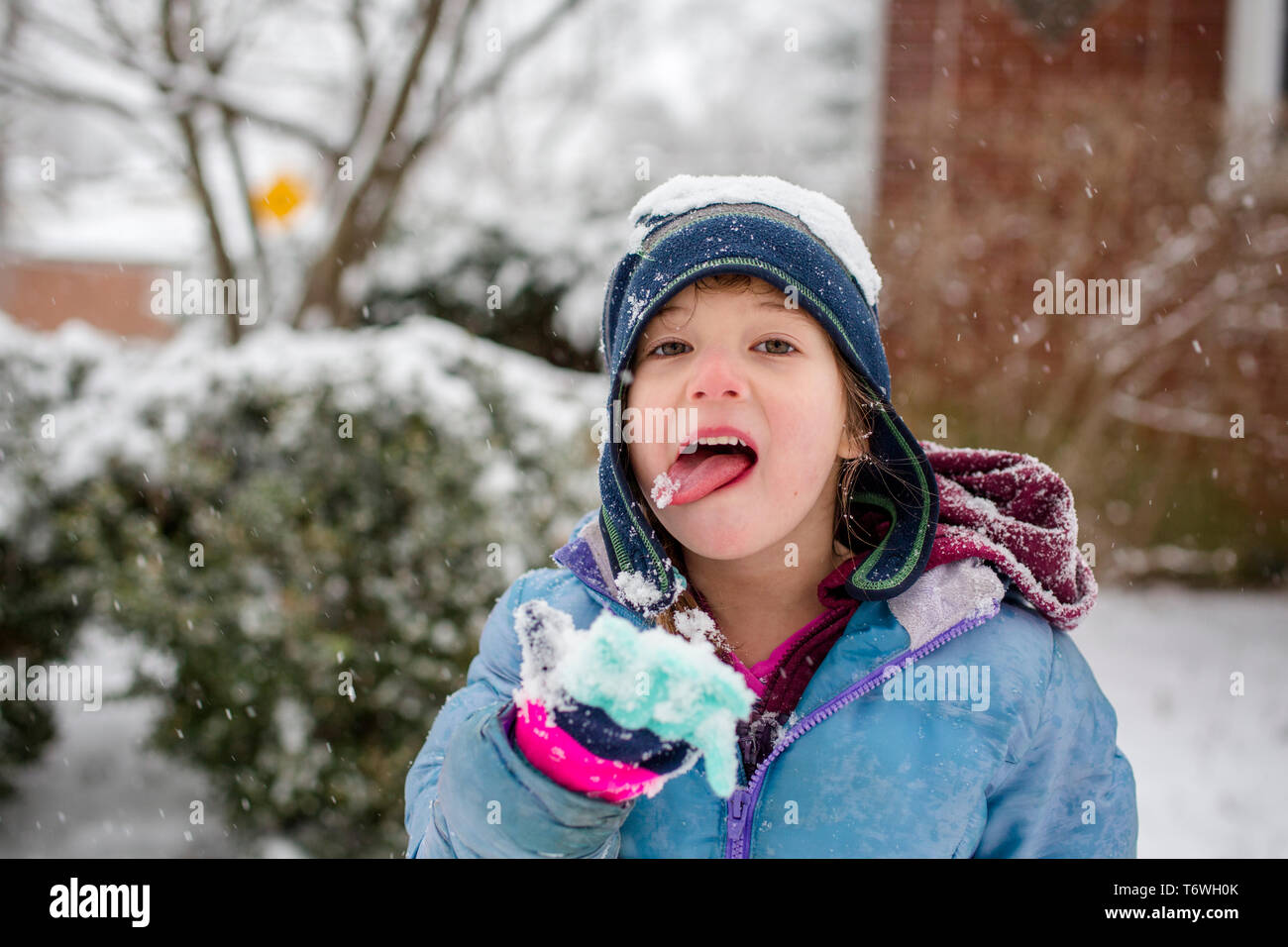 Haut de la moitié d'un petit enfant dans la neige qui tombe la neige de l'alimentation Banque D'Images