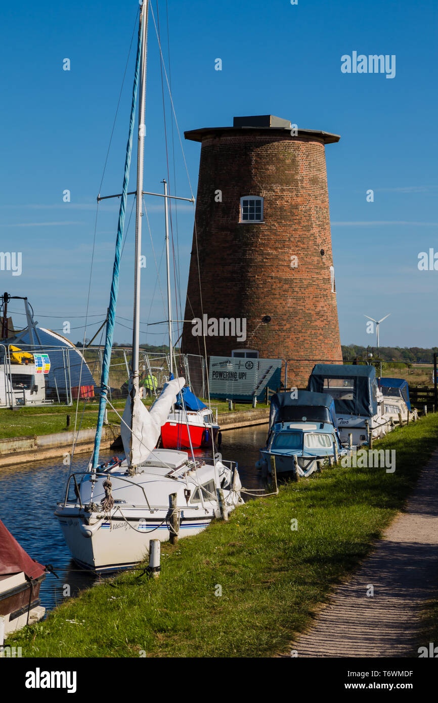 Horsey, Norfolk, Royaume-Uni. Horsey pompe éolienne en cours de restauration avec des bateaux au premier plan. Banque D'Images