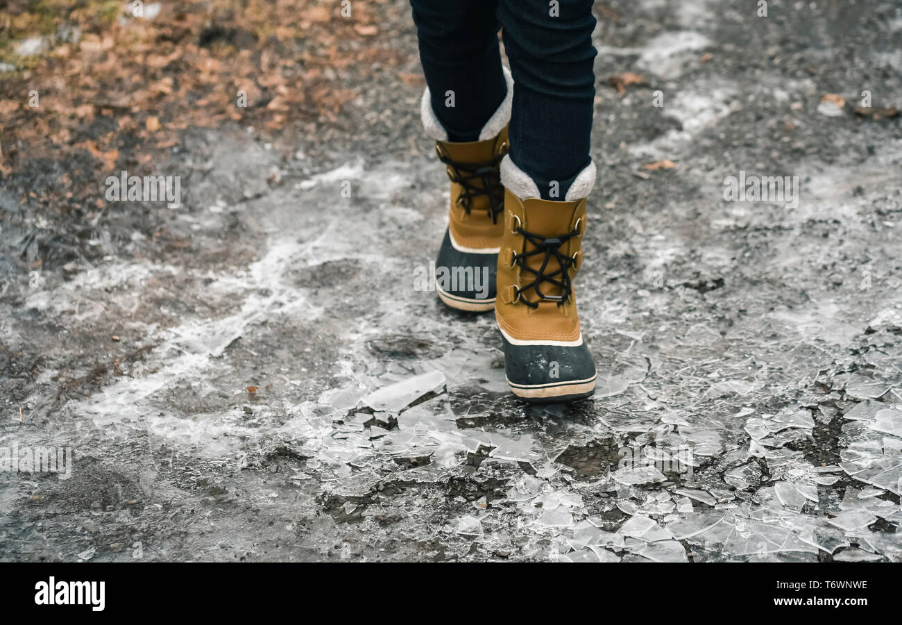Portrait Portrait de bottes d'hiver marche sur la glace fissurée en hiver. Banque D'Images