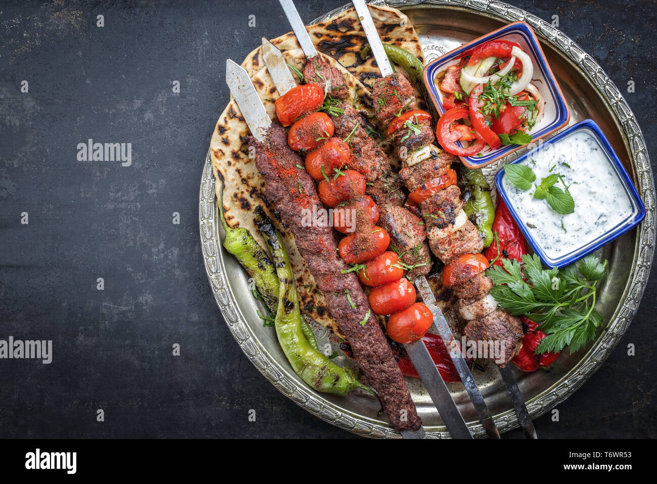 Adana kebap oriental traditionnel et des brochettes de tomates et de broche  avec du pain plat en vue d'en haut sur une plaque avec copie espace à  gauche Photo Stock - Alamy