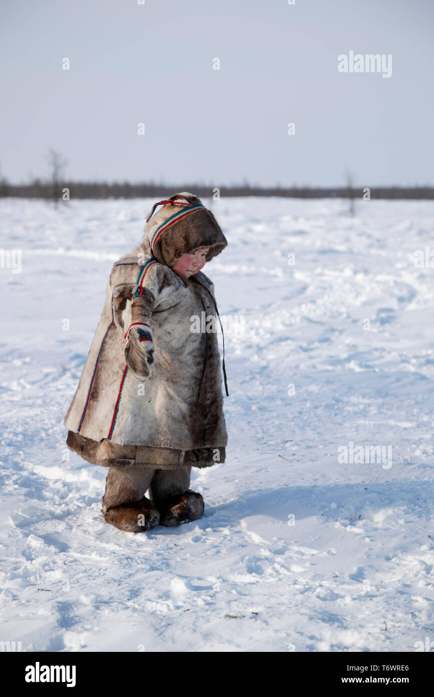La Russie, dans la région autonome de Yamal-Nenets, péninsule de Yamal. Camp de nomades éleveurs de rennes Nenets, jeune enfant en tenue traditionnelle. Banque D'Images