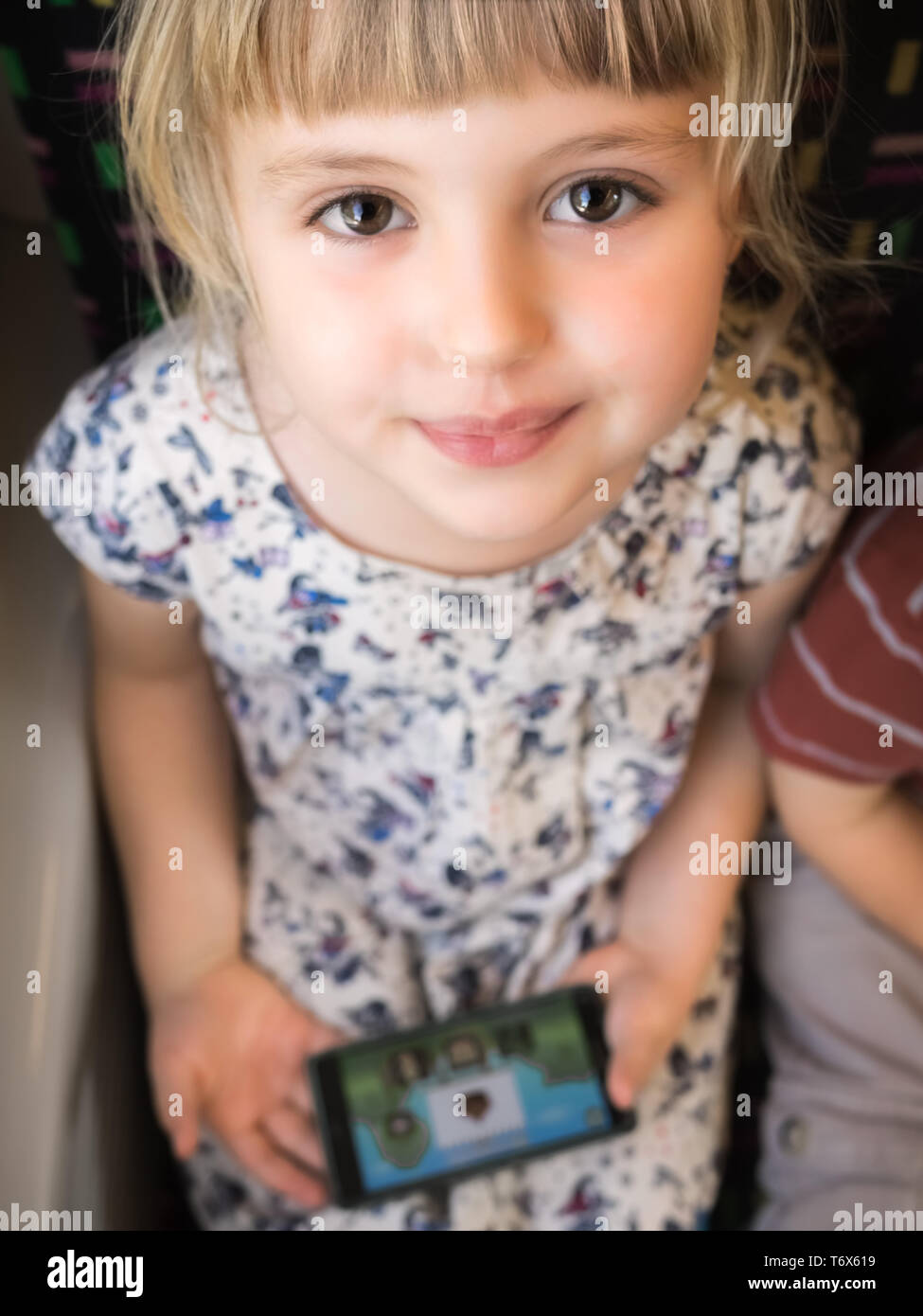 Little girl holding mobile phone Banque D'Images