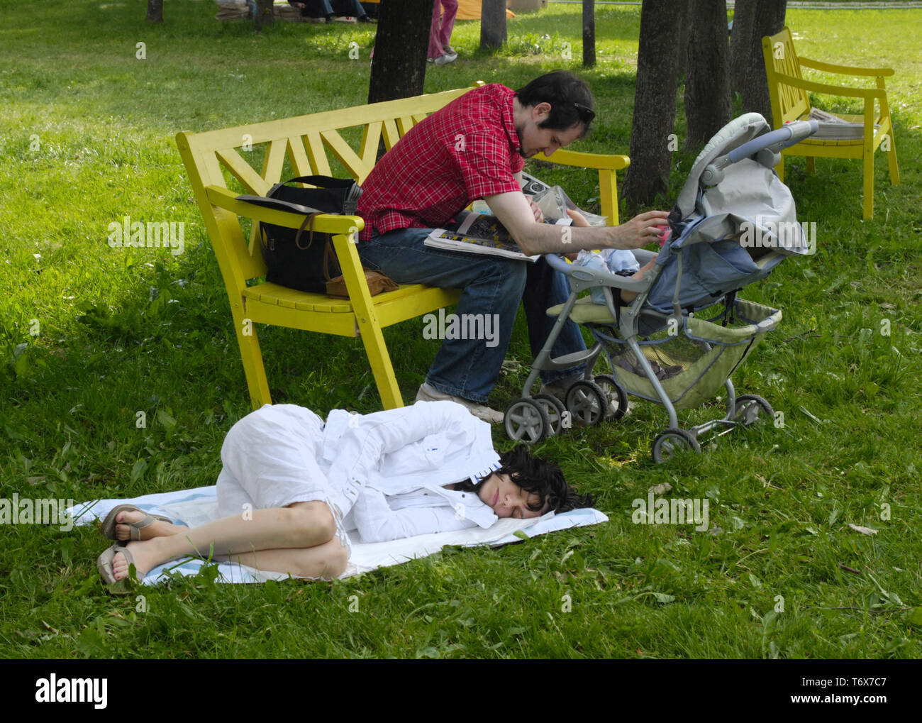 Les Jeunes Parents Avec Un Bebe Sur Le Banc A L Exterieur Fatigue Mere Dort Sur Le Terrain Photo Stock Alamy