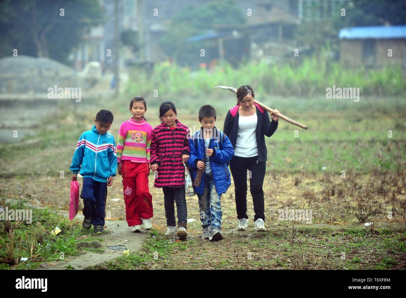 Beijing, Chine, région autonome Zhuang du Guangxi. Feb 25, 2013. Liang Lina et quatre élèves de son village à pied retour à Cannes Village de Wushi Canton de Luchuan County, Chine du Sud, région autonome Zhuang du Guangxi, le 25 février 2013. Credit : Huang Xiaobang/Xinhua/Alamy Live News Banque D'Images