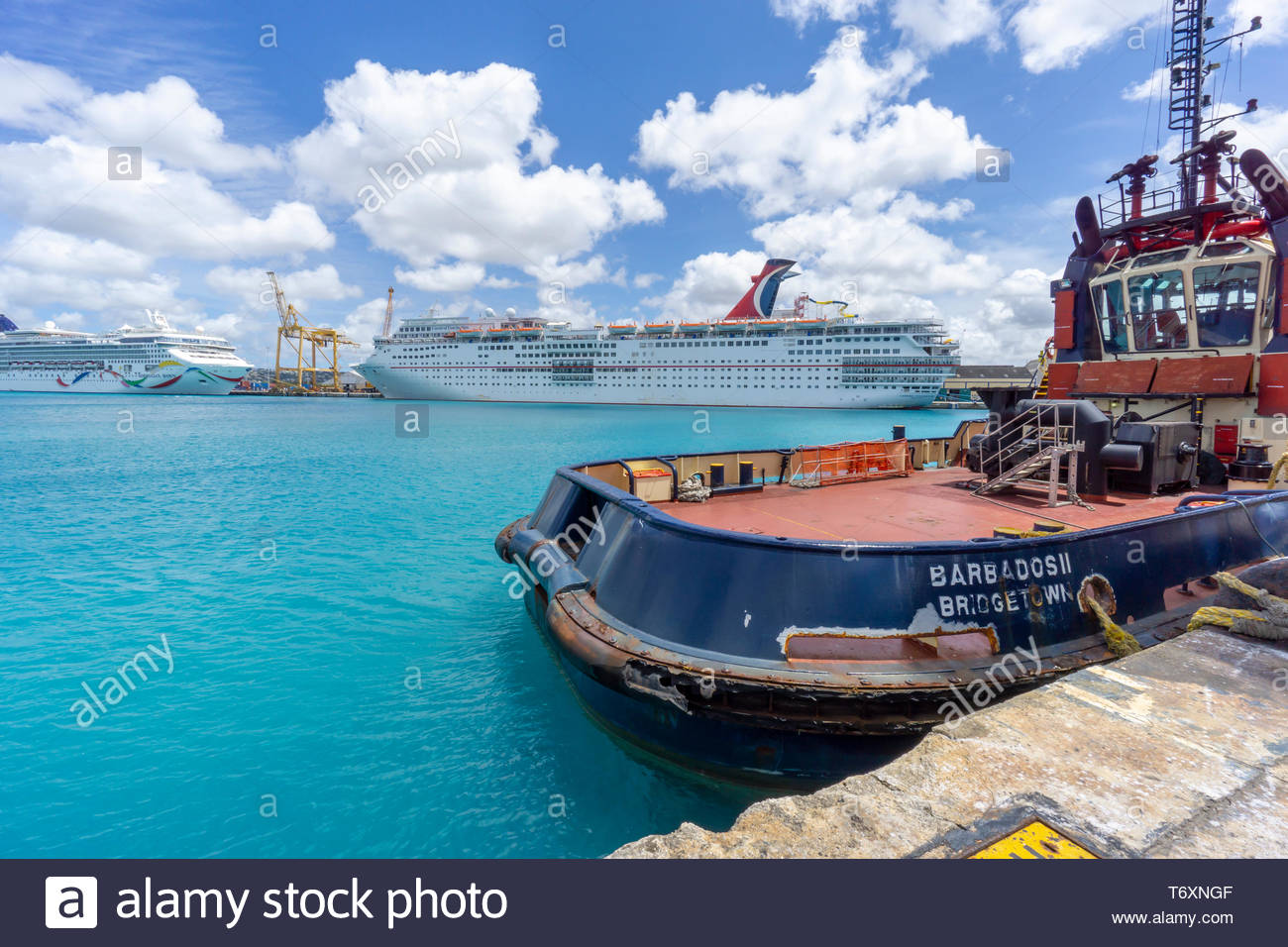 Deux bateau de croisière et un remorqueur dans le port de Bridgetown, à la Barbade, une île royaume de Commonwealth dans l'Atlantique Nord dans la région des Caraïbes. Banque D'Images