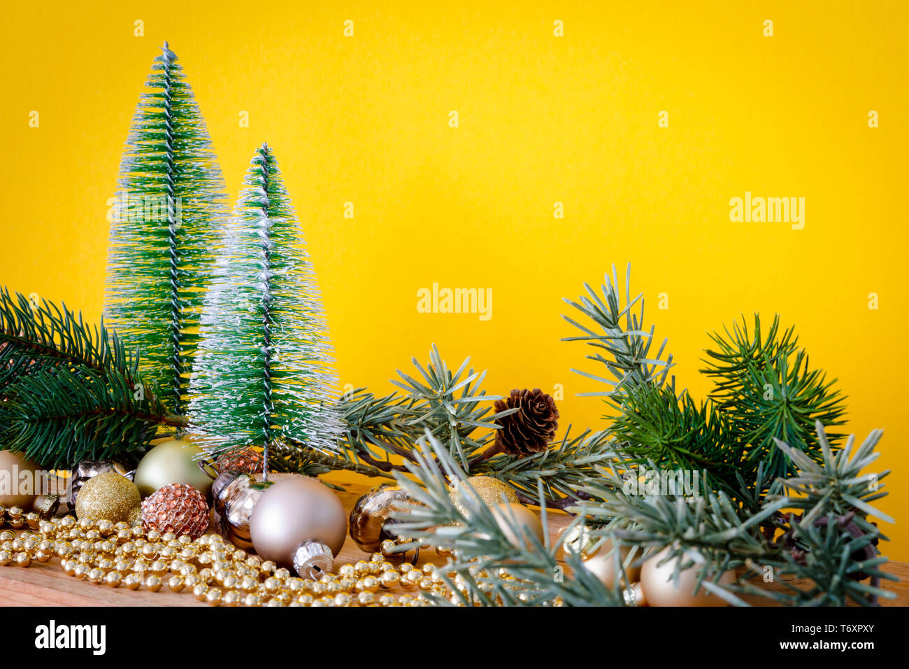 Boules de verre de décoration de Noël avec sapins sur fond jaune Banque D'Images