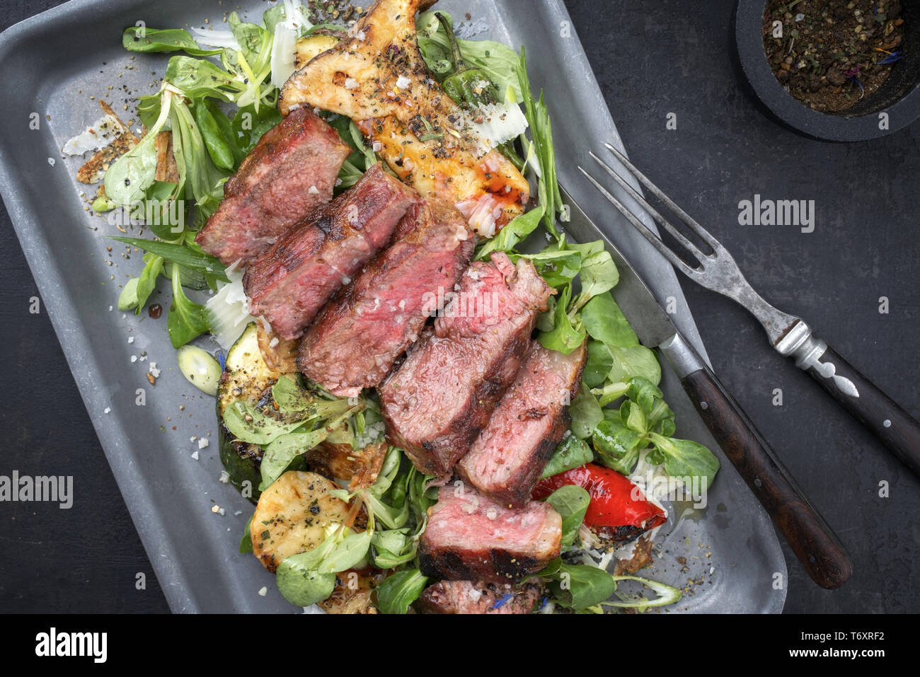Style moderne italien tagliata di manzo avec salade d'agneau rôti de boeuf en tranches d'âge à sec en vue de dessus dans une poêle Banque D'Images