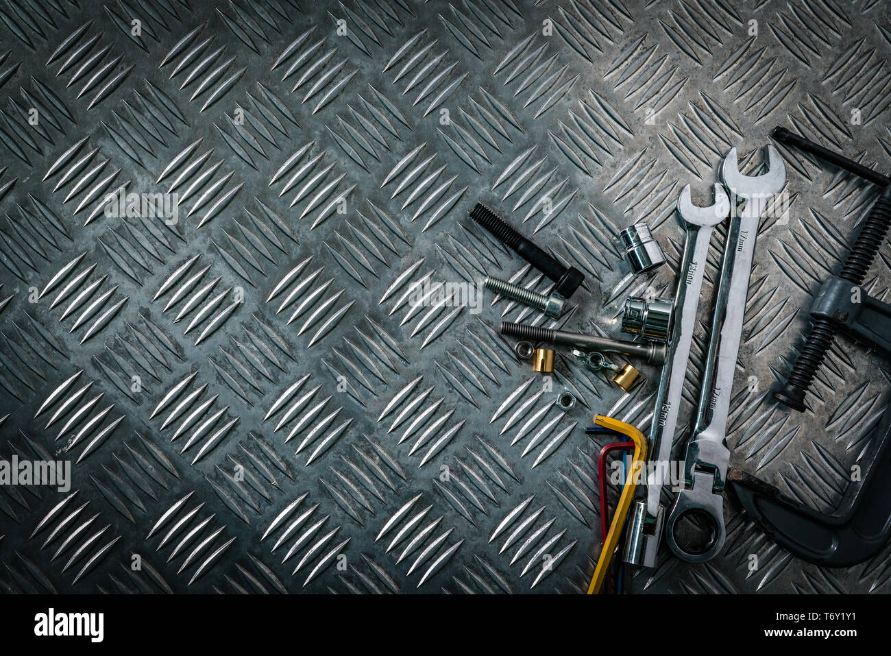 Vue de dessus d'outils sur des groupes metal checker plate. Pour checkerplate métal anti skid. Écrou, vis et clé hexadécimale sur feuille de métal-de-chaussée. Bosse d'argent Banque D'Images