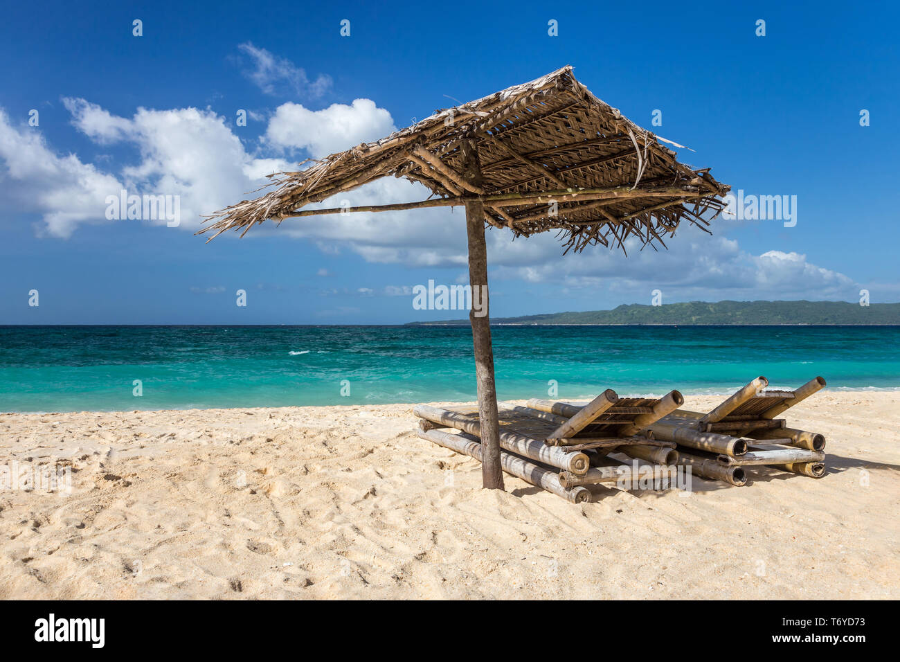 Des chaises longues et des parasols sur une plage de sable blanc Banque D'Images