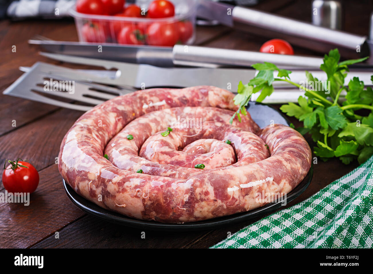 Des matières premières aux épices saucisse sur fond sombre Banque D'Images