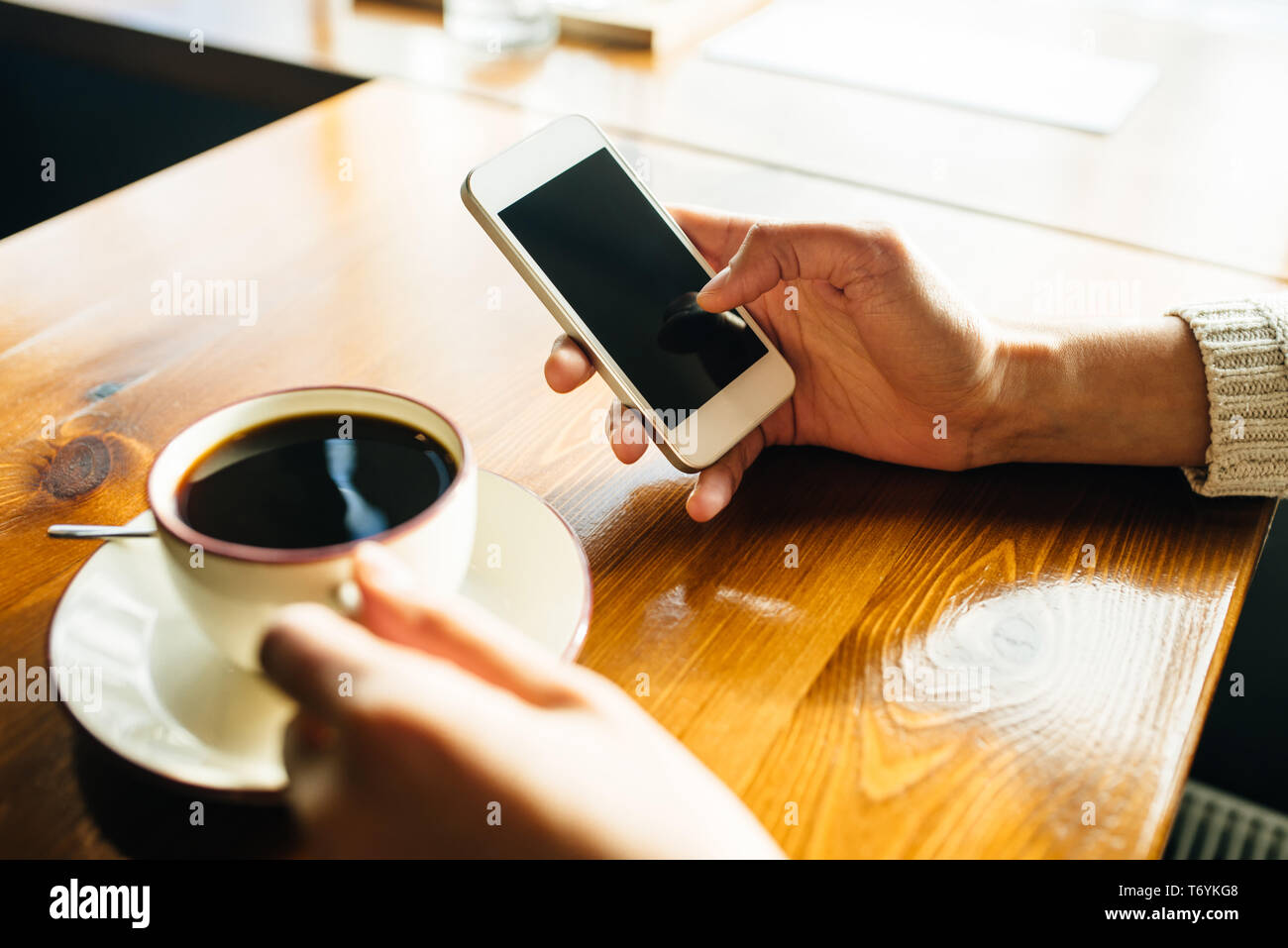 Femme à l'aide du smartphone sur table en bois dans le café. Image en gros plan avec les réseaux sociaux concept Banque D'Images