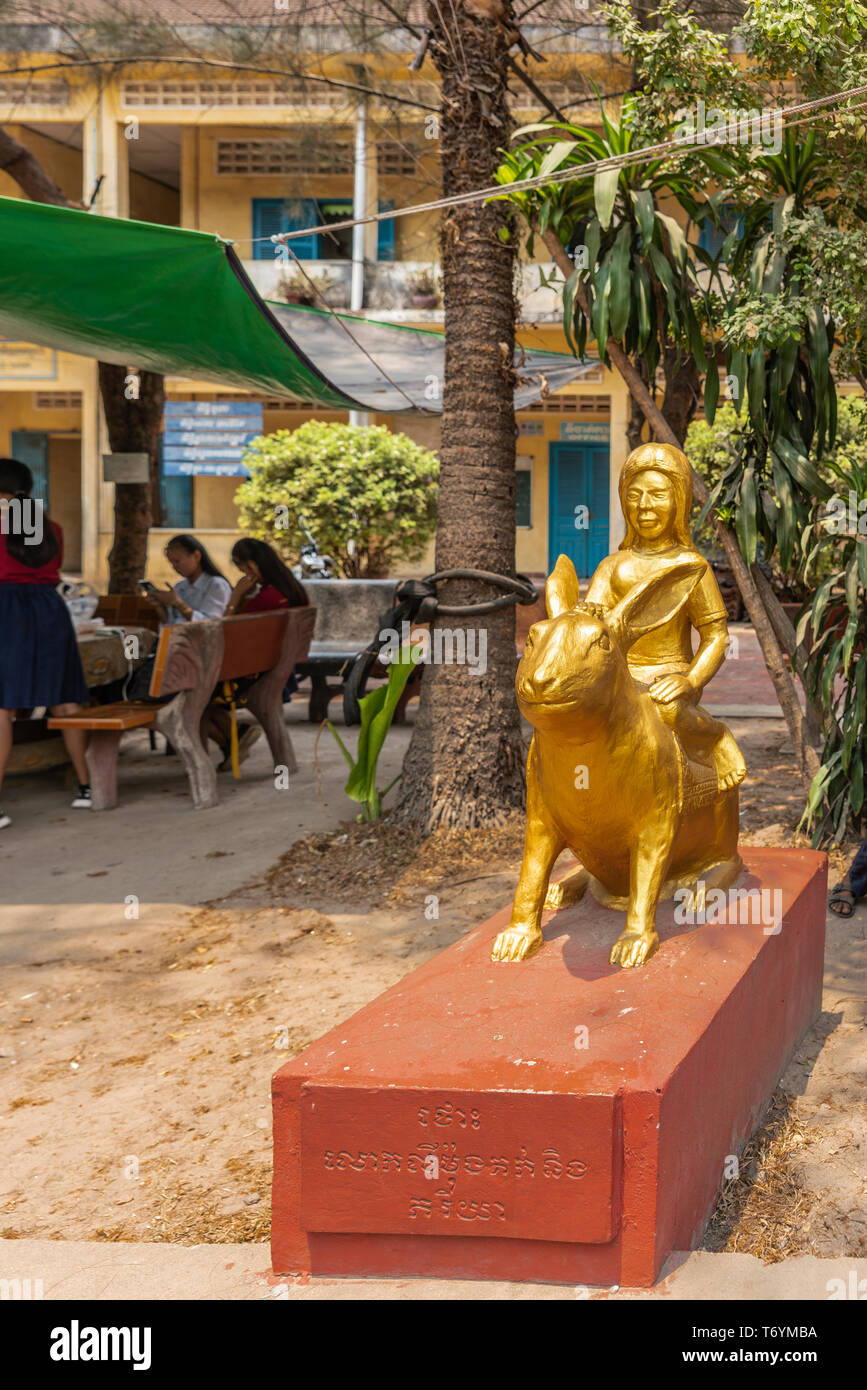 Sihanoukville, Cambodge - Mars 15, 2019 : Phsar Leu école élémentaire. Closeup portrait of statue en or de l'année de lapin, avec fille sur animal. P rouge Banque D'Images
