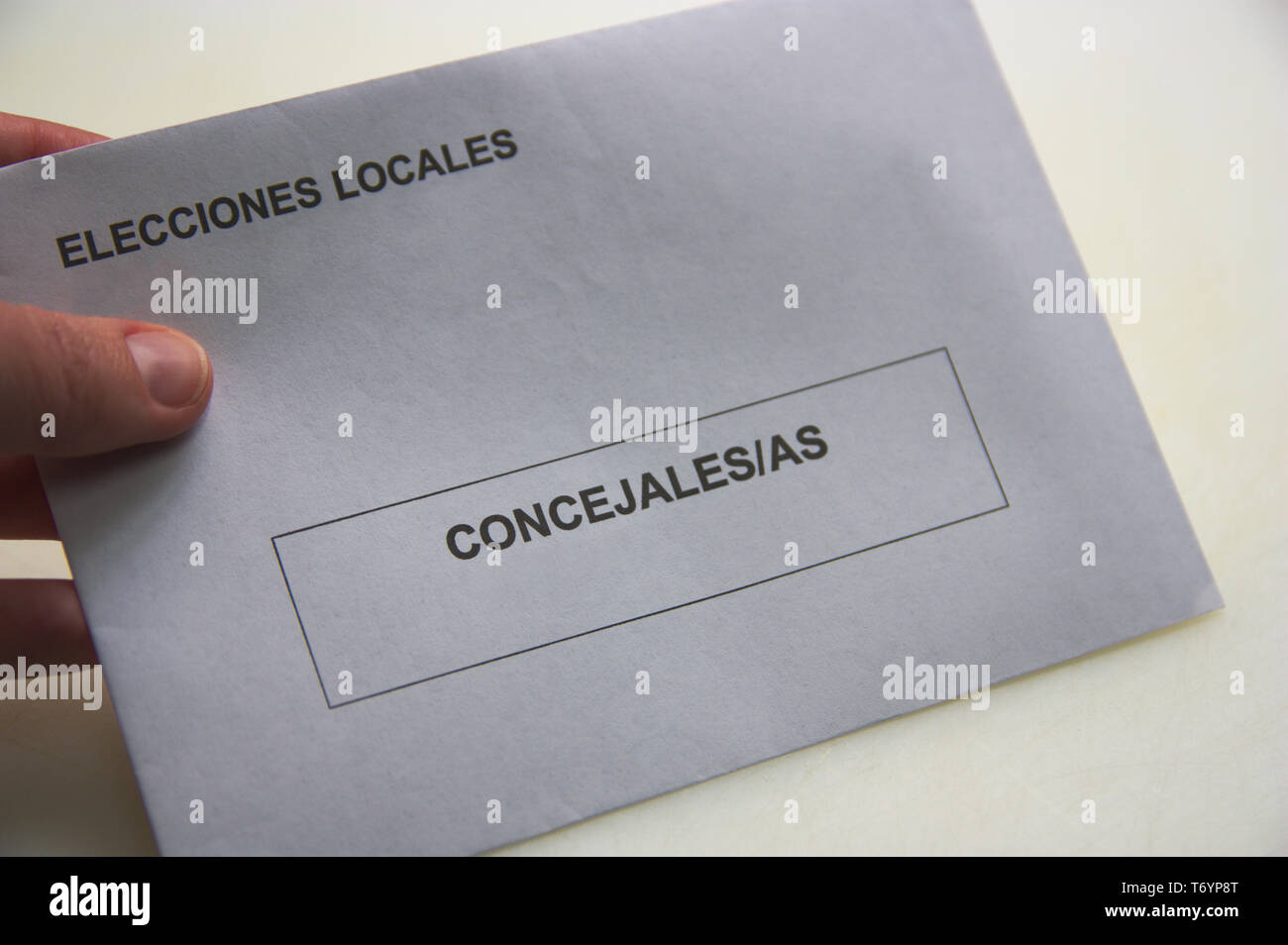 Quelqu'un détient une enveloppe dans laquelle il dépose le vote aux élections locales en Espagne. Apparaît écrit en espagnol : élections locales et les conseillers Banque D'Images