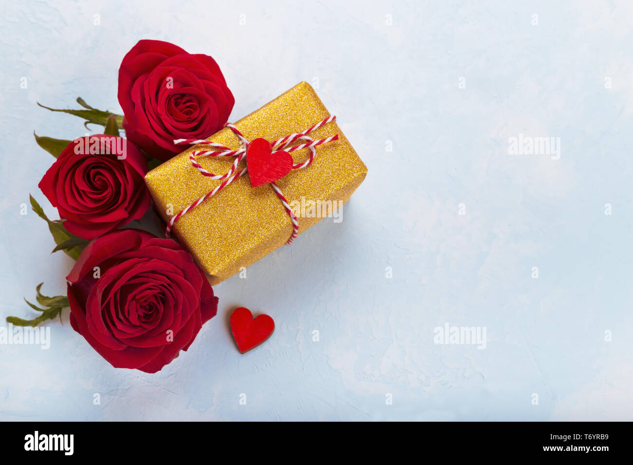 Roses rouges et golden gift box Banque D'Images
