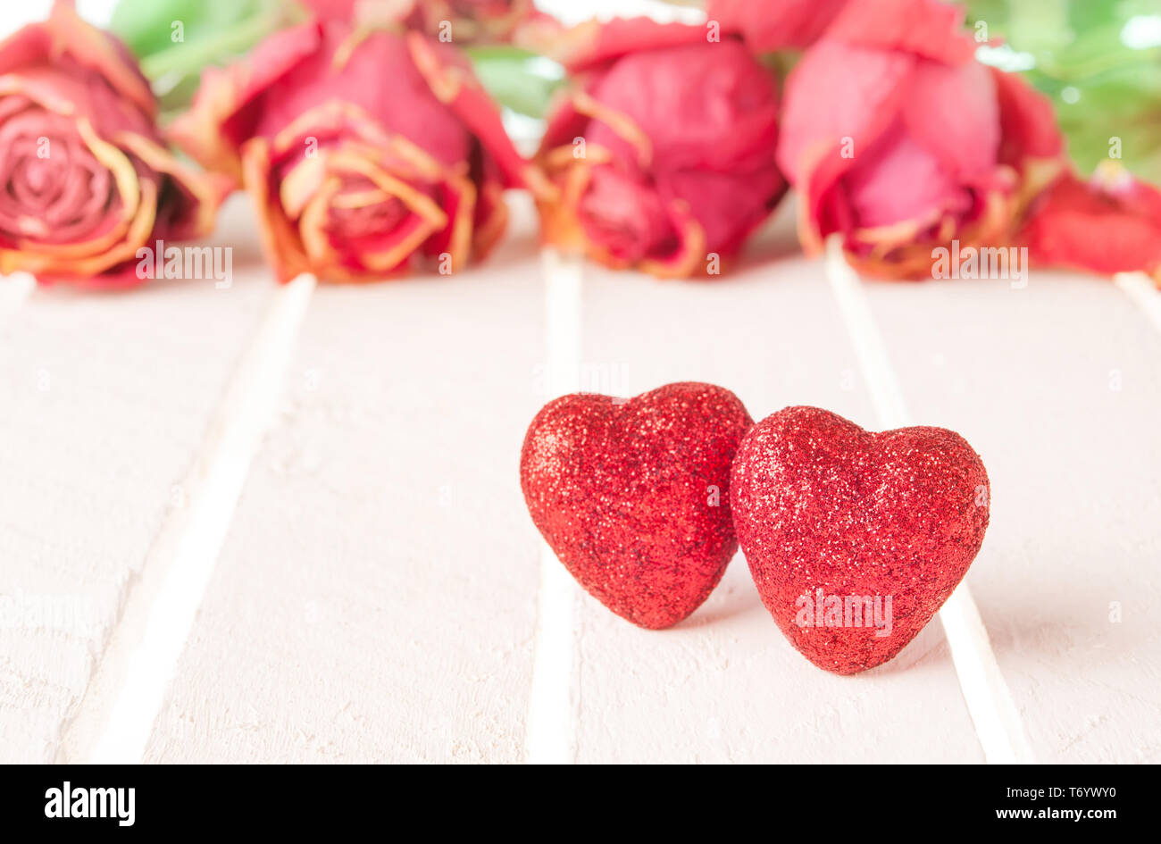 Deux coeurs rouges et roses sur fond de bois blanc. Banque D'Images