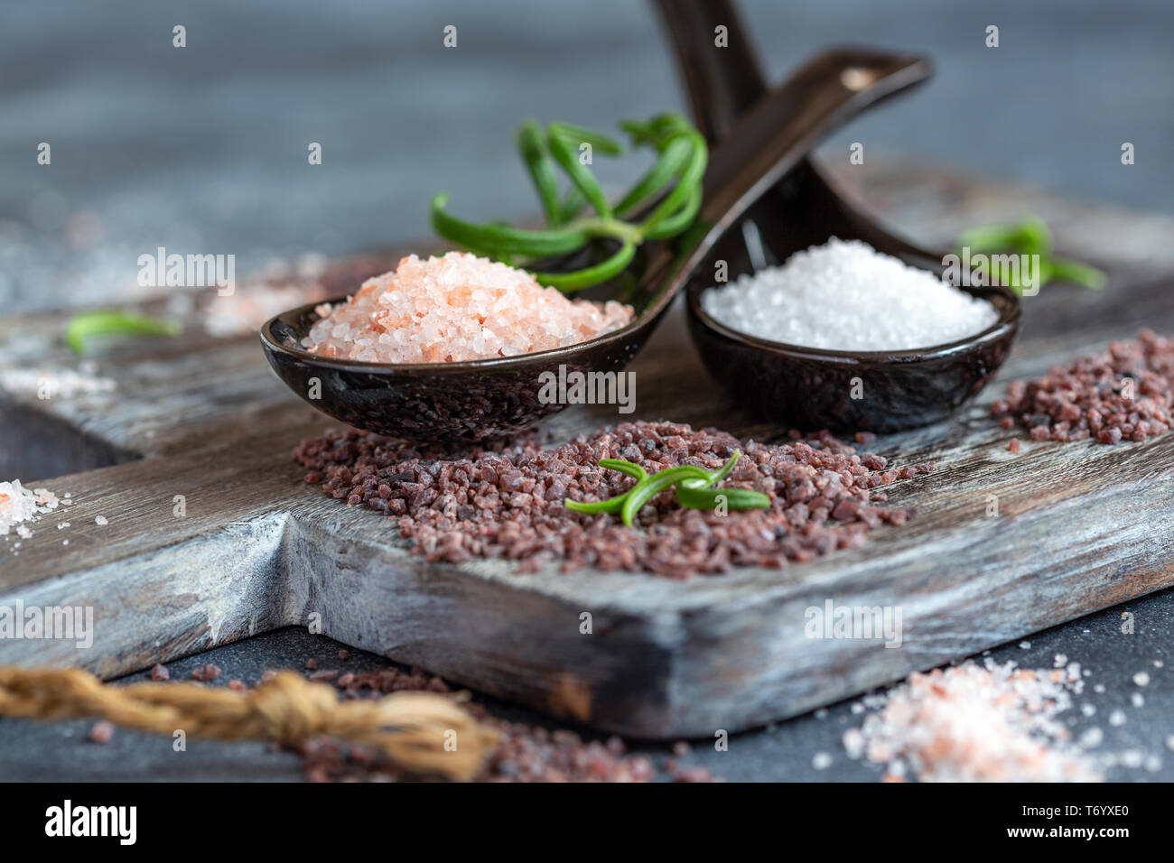 Les cuillères avec blanc, rose et noir de l'Himalaya de sel. Banque D'Images