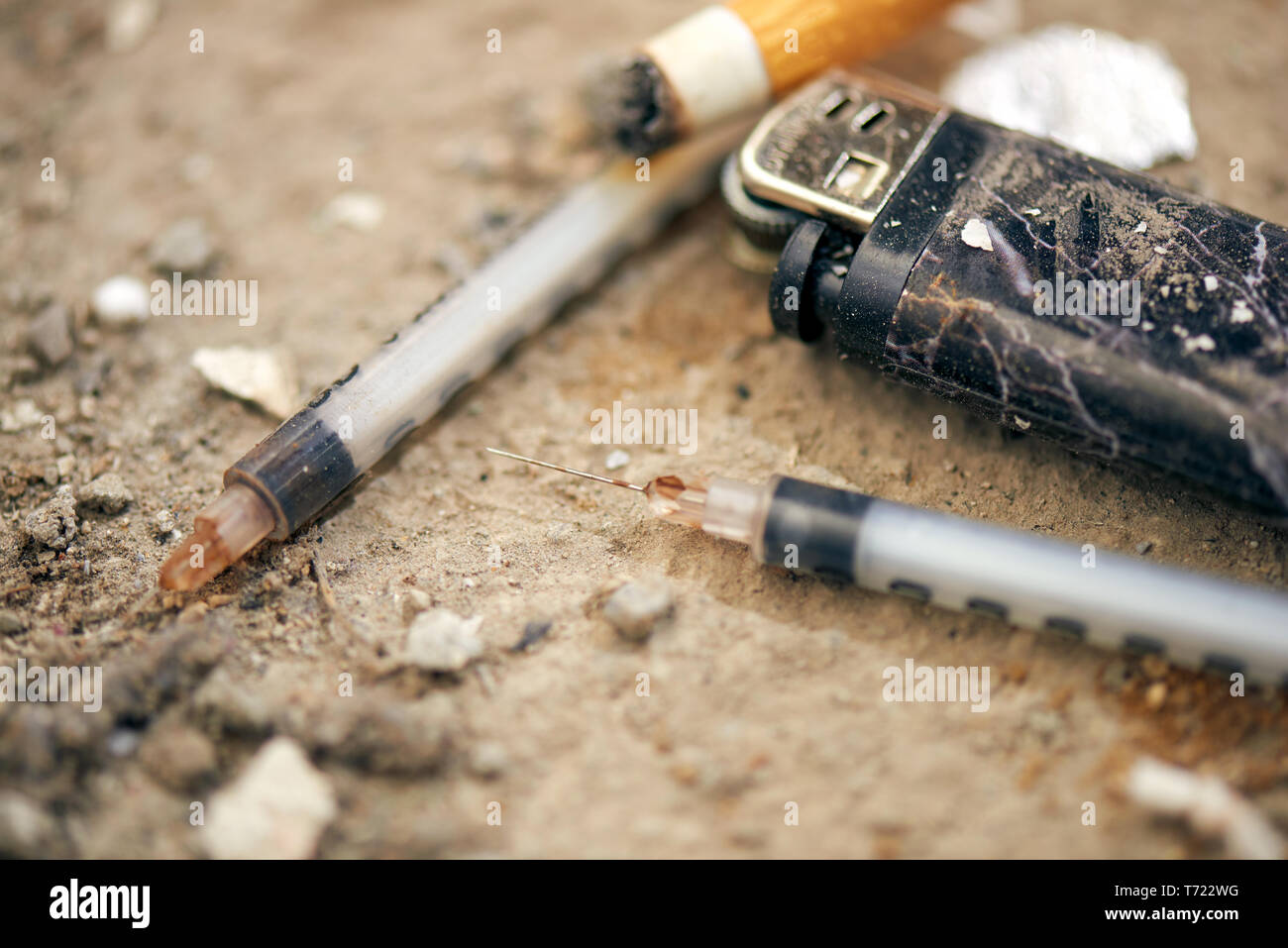Seringue utilisée sur le terrain - des toxicomanies de l'équipement. L'héroïne, seringue, allume-cigares - et des toxicomanies concept Banque D'Images
