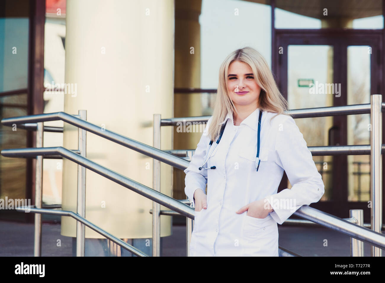 Closeup portrait of smiling confident female friendly, médecin, professionnel de la santé dans scrubs avec stéthoscope, debout à l'extérieur de l'hôpital backgroun Banque D'Images