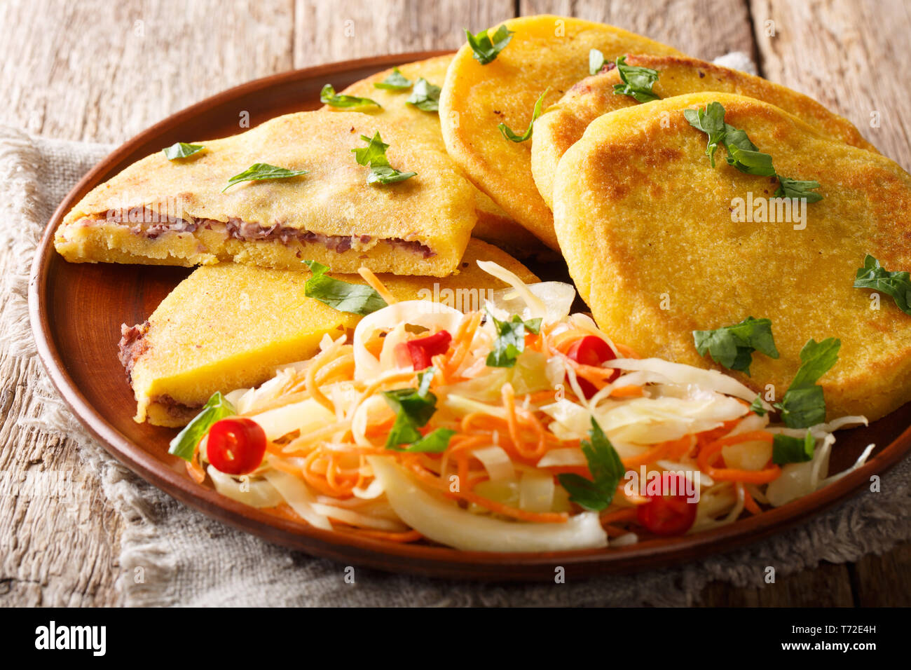 Pupusas frits végétariens délicieux servi avec de la salade de chou sur une assiette sur la table horizontale. Banque D'Images