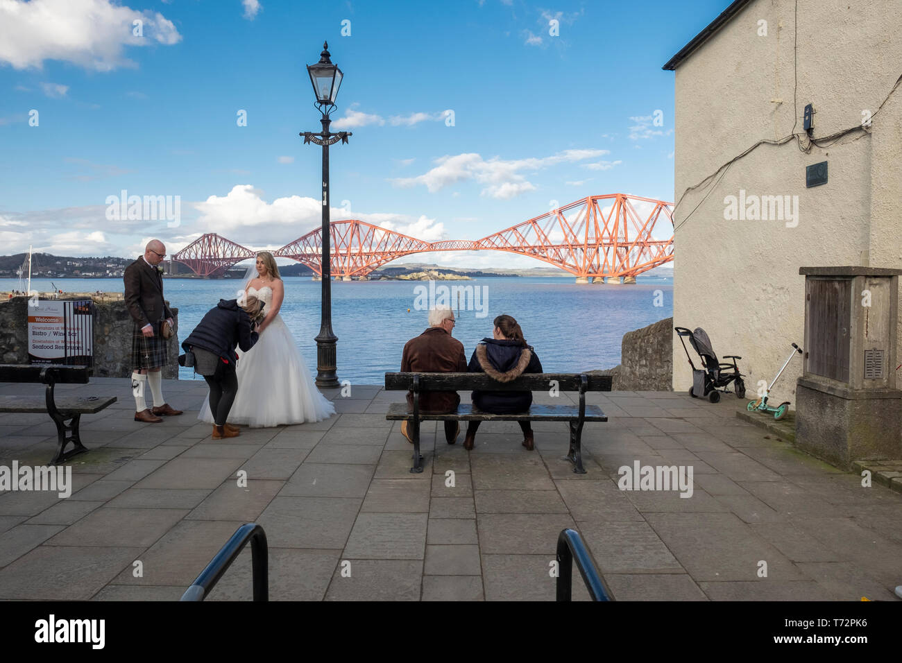 Mariée et le marié avec photographe de mariage dans la région de South Queensferry, avec le Forth Rail Bridge en arrière-plan, de l'Écosse Banque D'Images