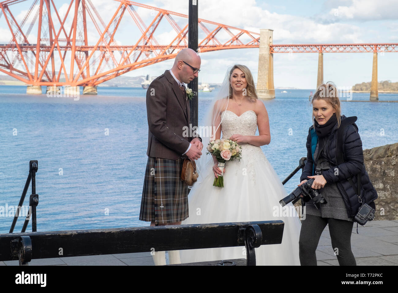 Mariée et le marié avec photographe de mariage dans la région de South Queensferry, avec le Forth Rail Bridge en arrière-plan, de l'Écosse Banque D'Images